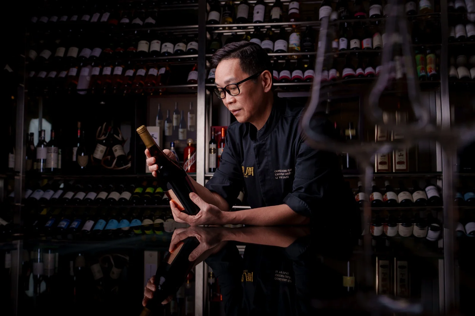 Chef Li Yuet-Faat selecting a bottle in the Ming Court wine cellar