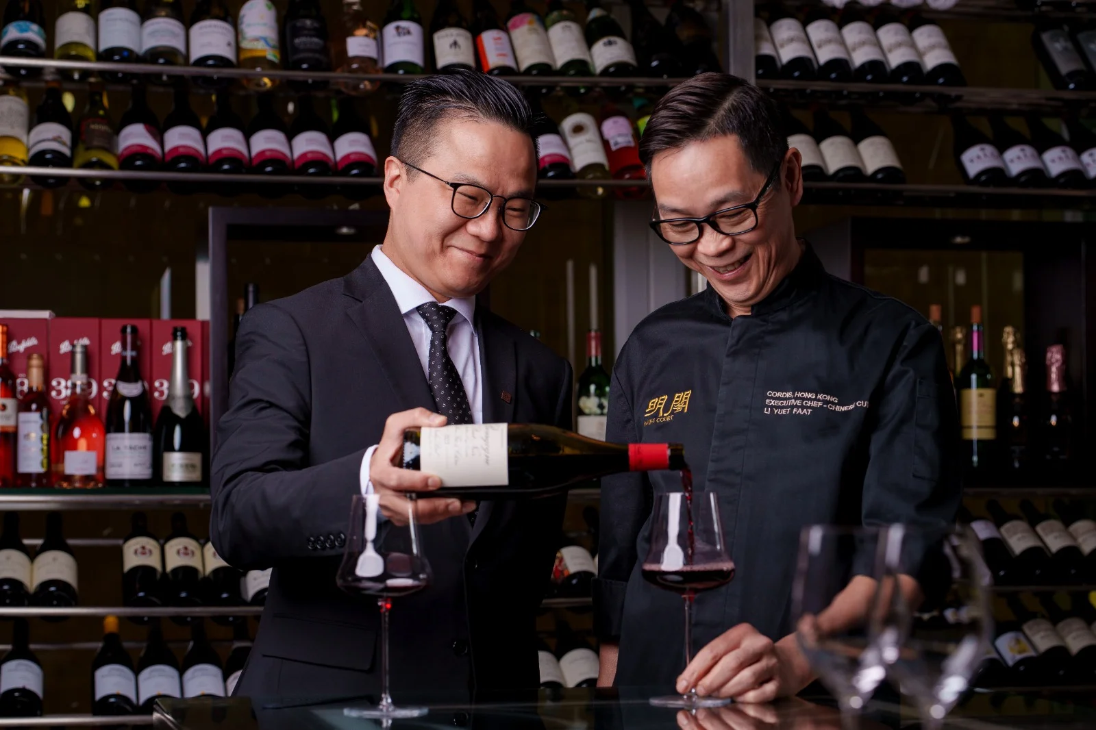 Noble Li and Chef Li Yuet-Faat examining a wine bottle